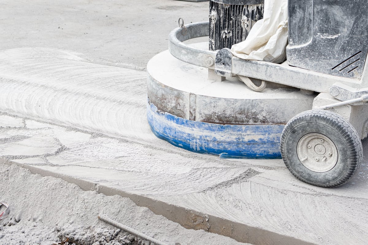 Industrial concrete floor grinder with dust extraction preparing a substrate before epoxy coating