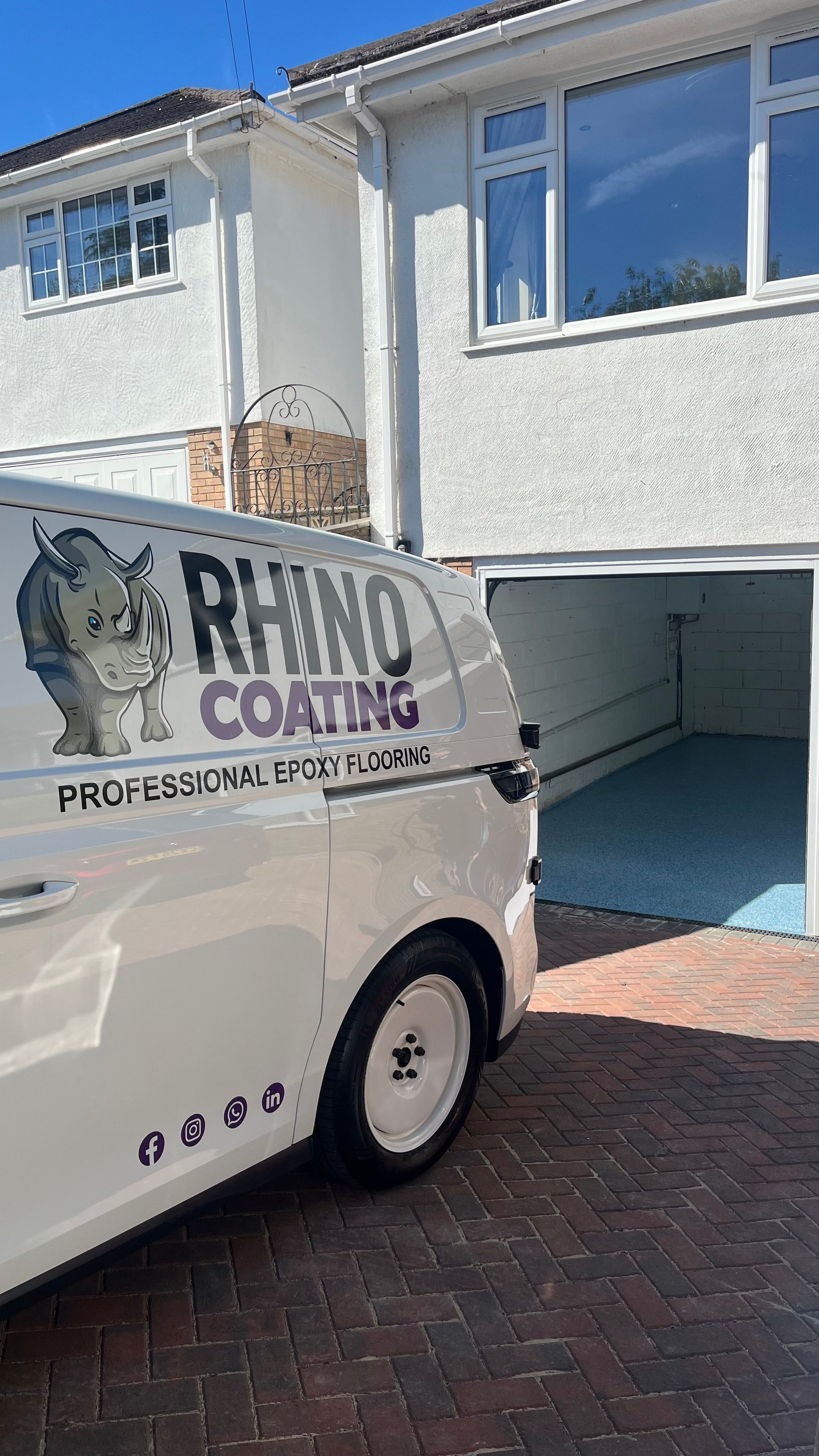 White service van with Rhino Coating logo parked in a driveway in front of a residential home with open garage door